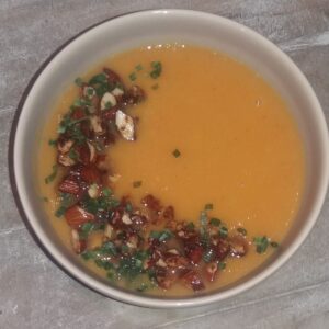 Soep van zoete aardappel (bataat) - met topping van geroosterde notenstukjes en groene kruiden