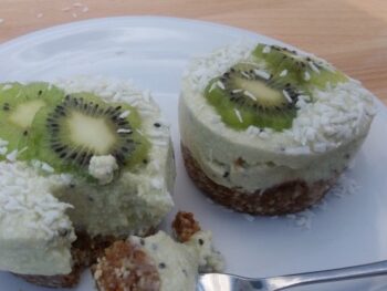 Lekkere kiwi-taartjes met kokosroom op een wit bord - glutenvrij en zonder zuivel